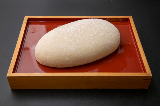白く大きな一升餅が朱塗りの箱に収まる