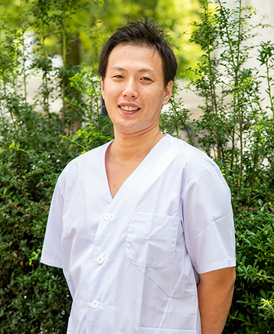 白衣姿でほほえむ、かどや3代目の関本真也さん